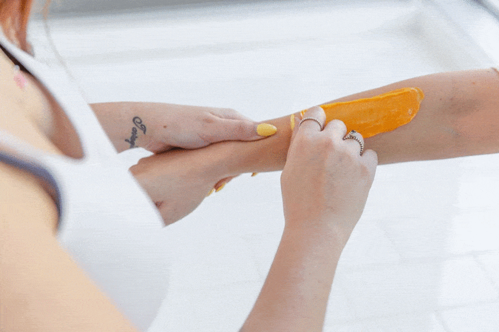 woman removing orange hair removal wax
