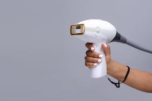a hand holding a laser hair removal machine